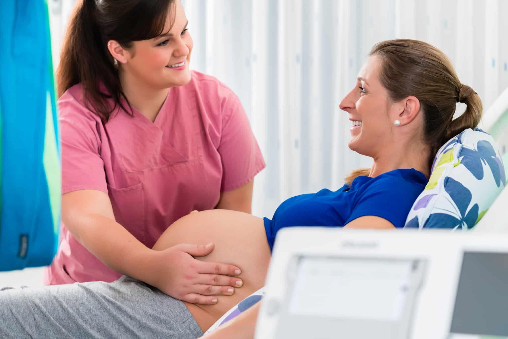 Midwife assisting a pregnant woman in the delivery room